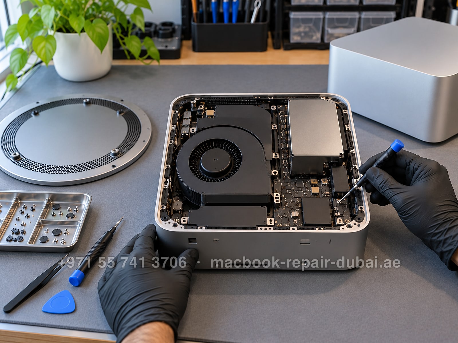 Mac Studio M5 repair in Dubai: a Mac Studio opened upside down on a repair bench with the base plate removed, showing the blower fan and logic board