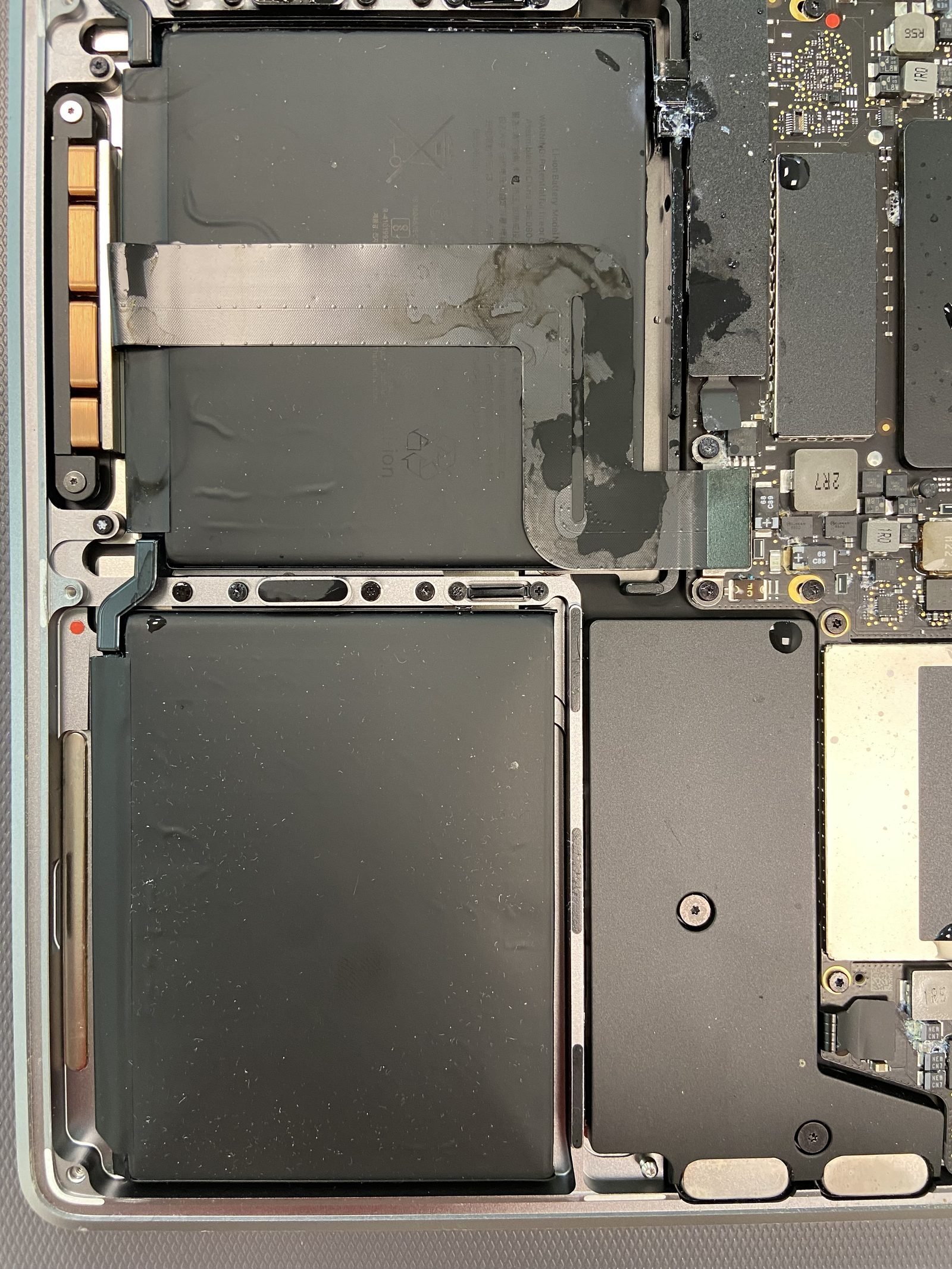 MacBook battery and logic board exposed during a battery replacement in Dubai