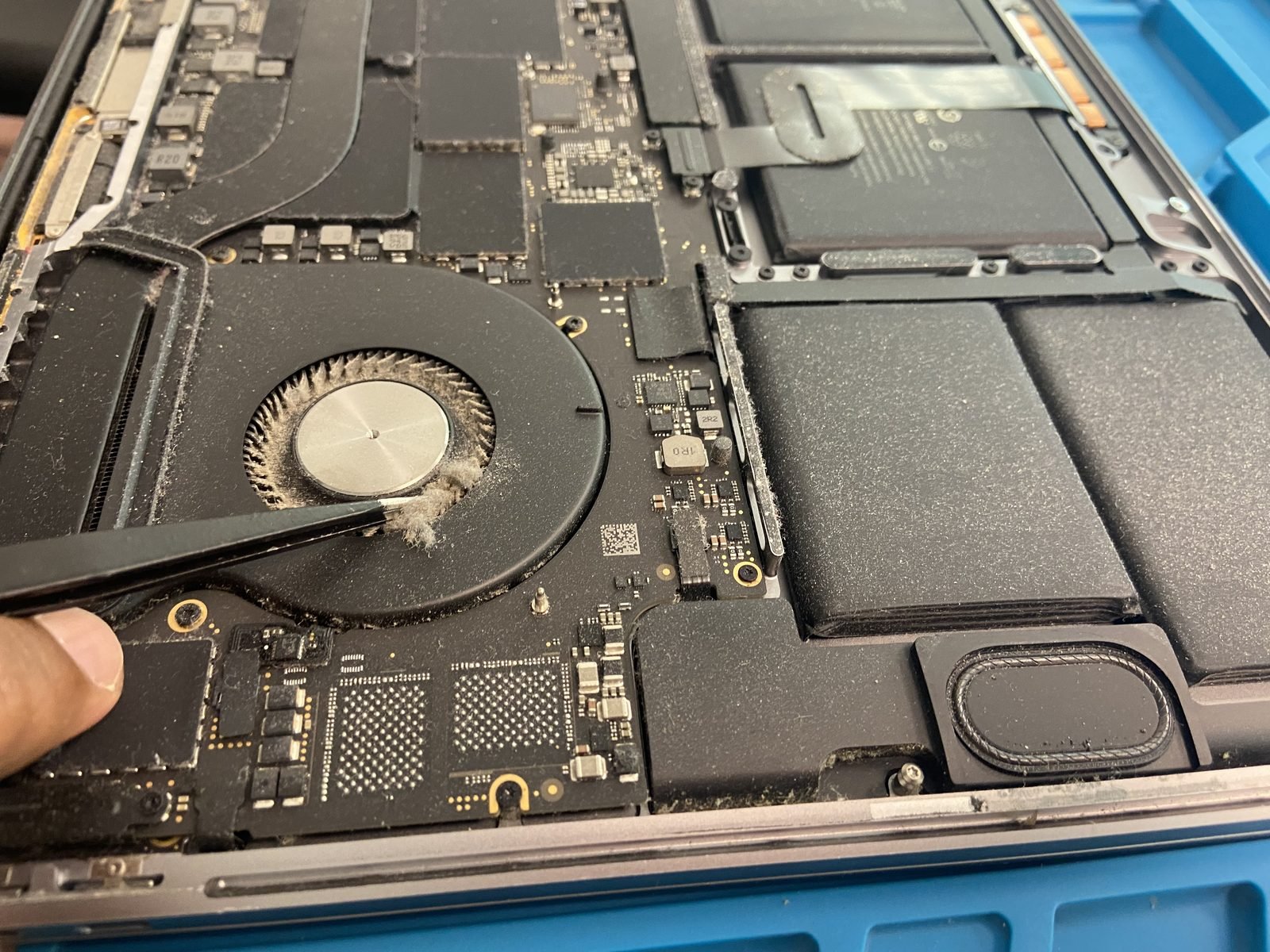 MacBook Repair Dubai technician servicing a MacBook Pro cooling fan and logic board at the Media City workshop