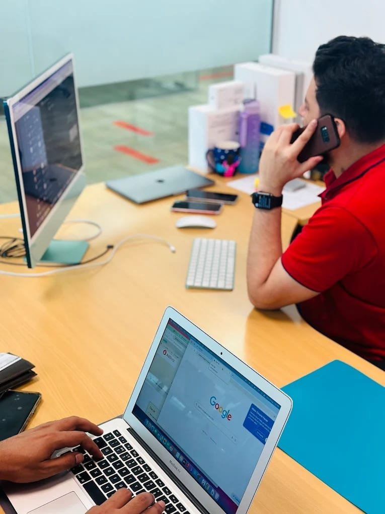 Technician on a customer support call while diagnosing a MacBook Air at MacBook Repair Dubai, Dubai Media City